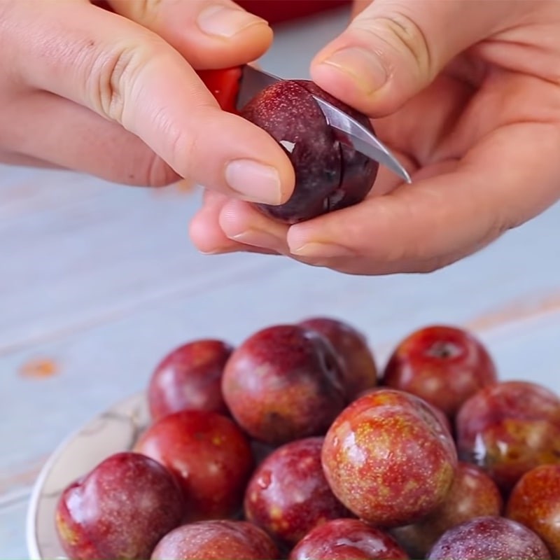 Dùng dao để rạch hình chữ thập trên quả mận